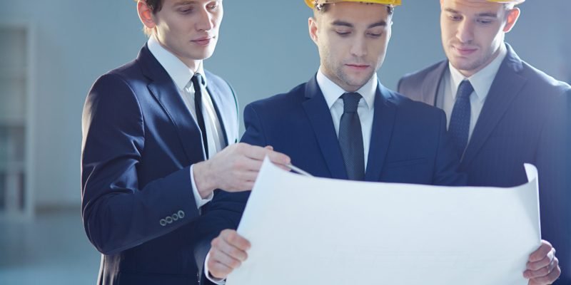 Closeup image of three constructors developing the business project